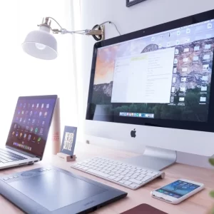 iMac, laptop and phone on workstation table